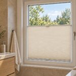Sfeerimpressie van een LIVA honinggraatplissé met plakstrips zonder boren in een beige badkamer